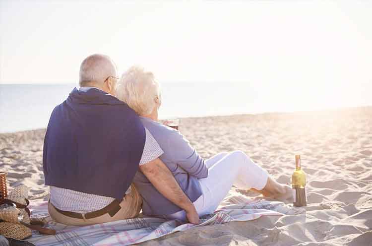Senior couple sitting and looking at the sunset
